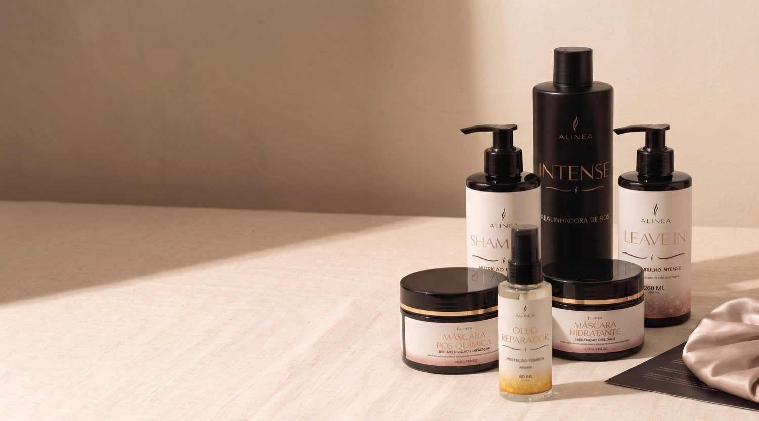Os seis produtos da linha Alinea sobre mesa de linho claro, com a realinhadora Intense ao centro